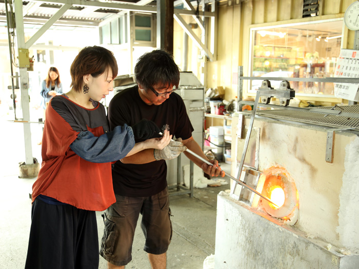 「吹きガラス簡単コース」 1.1300℃にもなる窯の中で溶けたガラスをすくいとる。