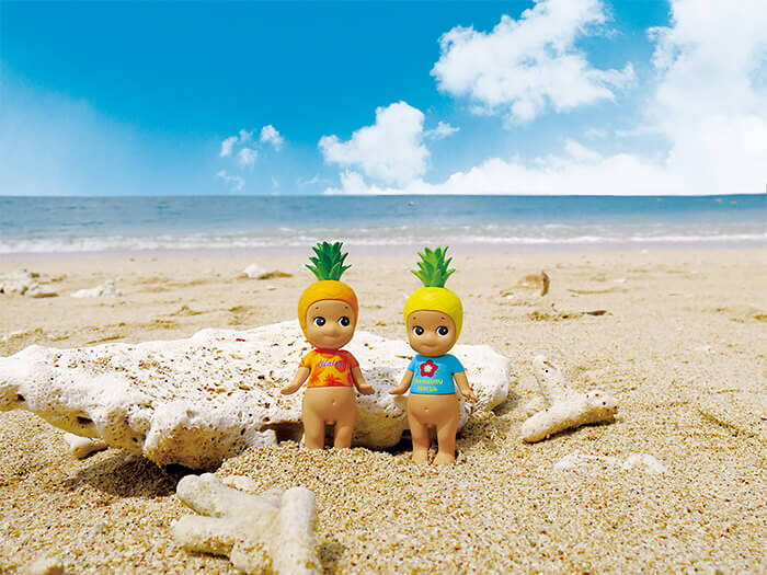 Mini figurines planned to be sold from this summer only in Okinawa. The T-shirt adorned with Okinawan words on suntanned skin is really cute.