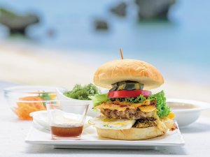 A hamburger made with seasonal ingredients. Take a big bite to enjoy its flavor and aroma. The blue ocean and blue sky expand in front of you.